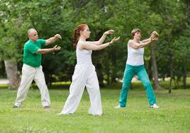 Groupe de personnes qui font du qi gong en pleine nature